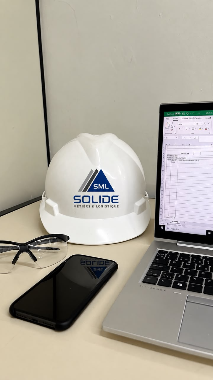 Casque de chantier portant le logo SML, sur un bureau de préparation